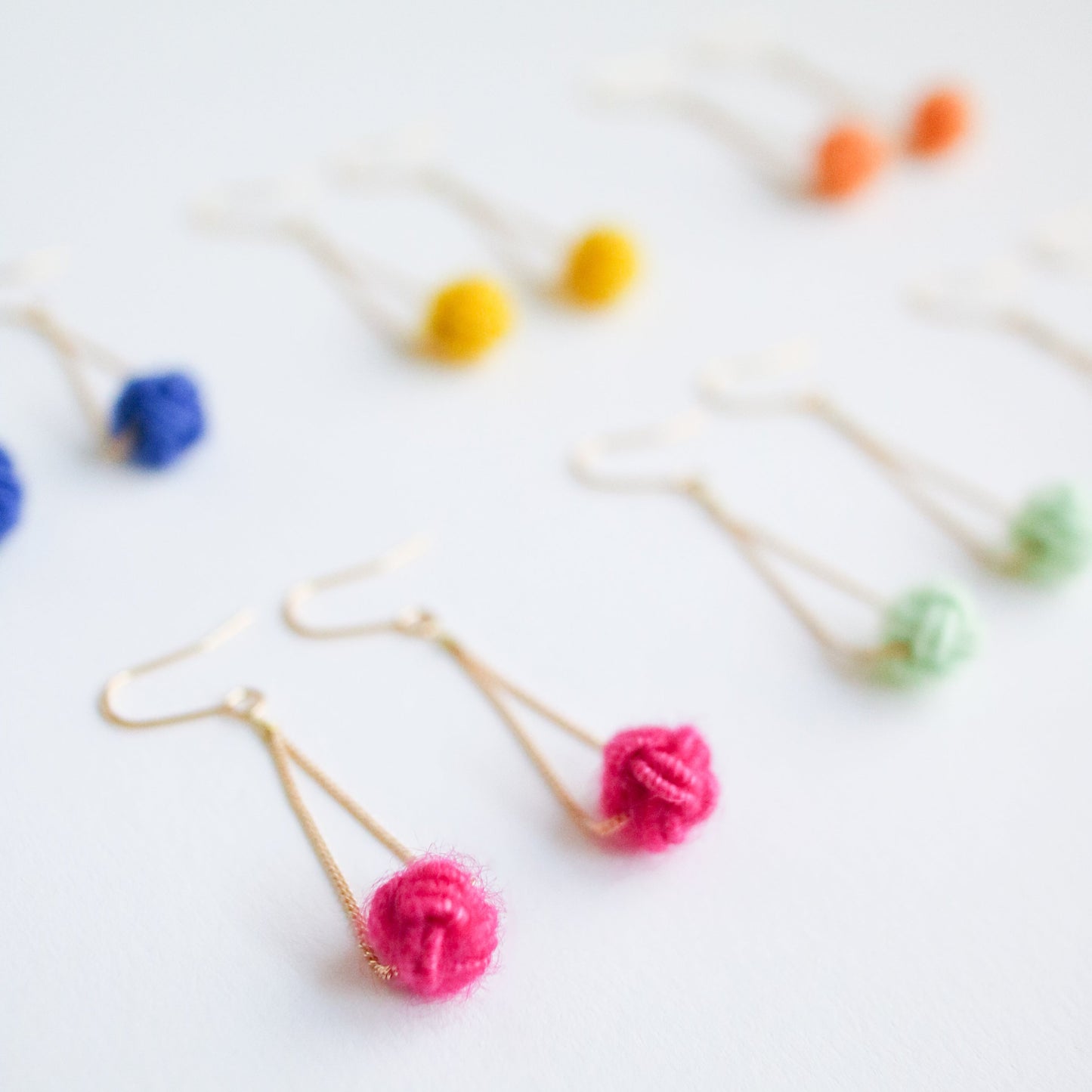 Colorful brooches with yarn balls on a white background